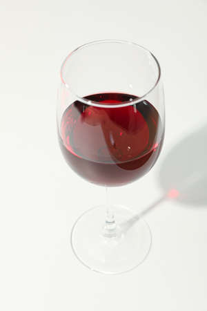 Glass with red wine on white background, copy space