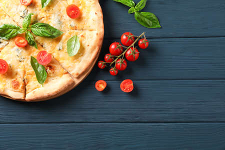 Cheese pizza with tomatoes and basil on wooden background, copy spaceの写真素材