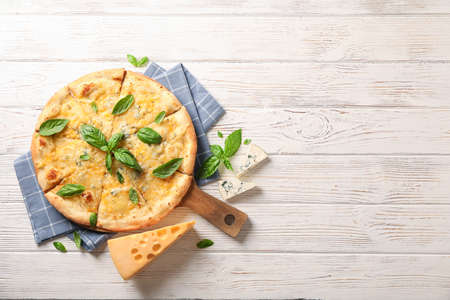 Towel, board, cheese pizza with basil on wooden background, copy spaceの写真素材