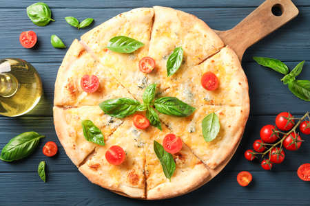 Cheese pizza, tomatoes and olive oil on wooden background, top viewの写真素材