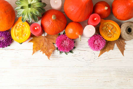 Composition with pumpkins, flowers and candles on white wooden  background, copy spaceの写真素材