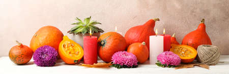 Composition with pumpkins, flowers and candles on white wooden  background, copy spaceの写真素材