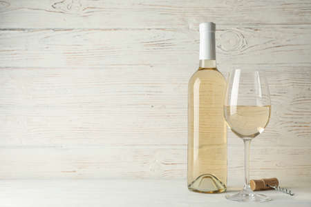 Corkscrew, bottle and glass with wine on white wooden background, copy spaceの写真素材