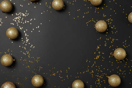 Christmas balls and glitter on black background, top view