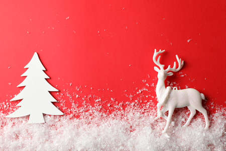 Snow, decorative trees and reindeer on red background, space for textの写真素材