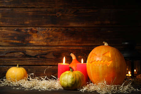 Halloween pumpkins and candles on dark wooden background, copy spaceの写真素材