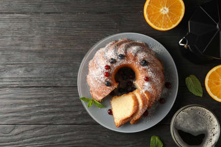 Cake with powdered sugar, berries and mint on wooden background, top viewの写真素材