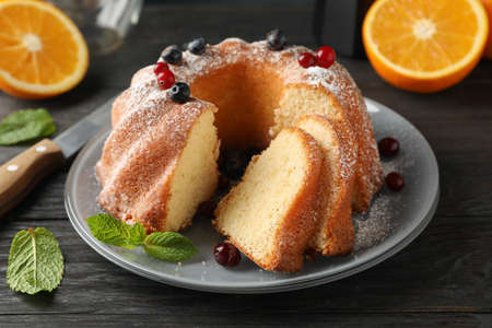 Cake with powdered sugar, berries and mint on wooden background, close upの写真素材