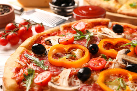 Delicious pizza and ingredients on white wooden background, close upの写真素材