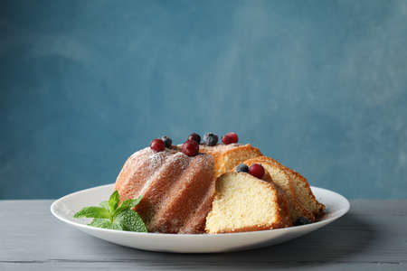 Cake with powder sugar and berries on wooden background, space for textの写真素材