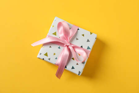 Gift box with bow on yellow background, space for textの写真素材
