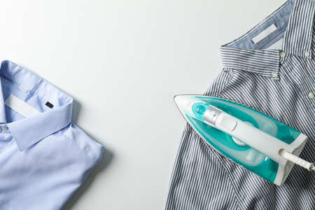 Iron and shirts on white background, top viewの写真素材