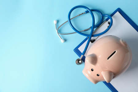 Stethoscope and piggy bank on blue background, space for textの写真素材