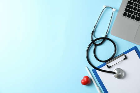 Stethoscope, laptop, tablet, pen and heart on blue background, space for textの写真素材