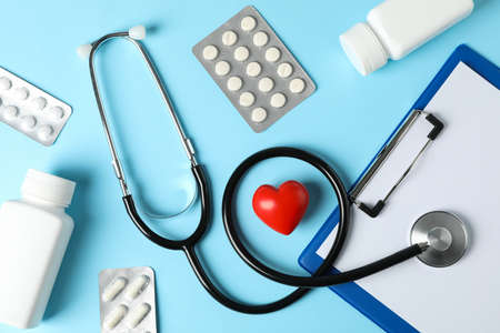 Stethoscope, tablet, heart and medicine on blue background, top viewの写真素材