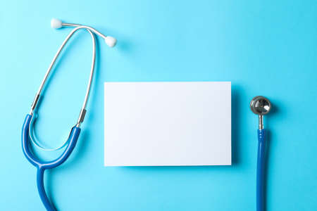 Stethoscope and notepad on a blue background, space for textの写真素材