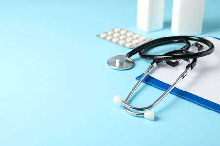 Stethoscope, tablet and medicine on blue background, space for textの写真素材