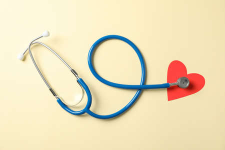Stethoscope and heart on beige background, space for text. Healthcareの写真素材
