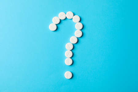Question mark layd out of pills on blue background, space for textの写真素材