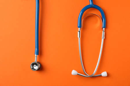 Stethoscope on orange background, space for text. Healthcareの写真素材