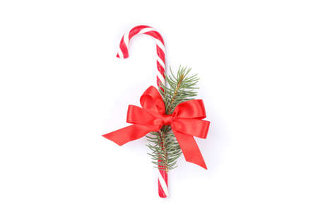 Candy cane with bow and fir branch isolated on white backgroundの写真素材