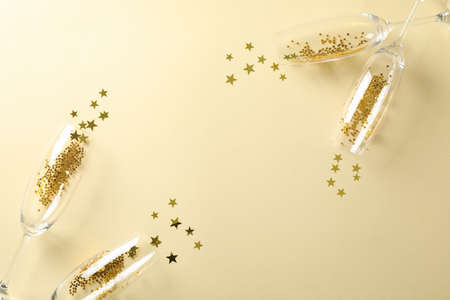 Champagne glasses with glitter on beige background, space for textの写真素材