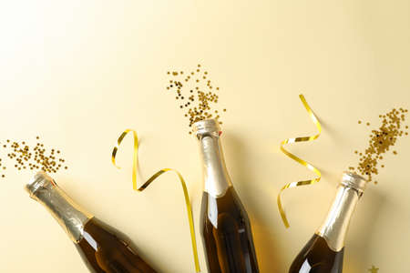 Champagne bottles and glitter on beige background. Holiday conceptの写真素材