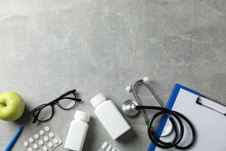 Stethoscope and medicines on grey background, top view. Doctor workplaceの写真素材