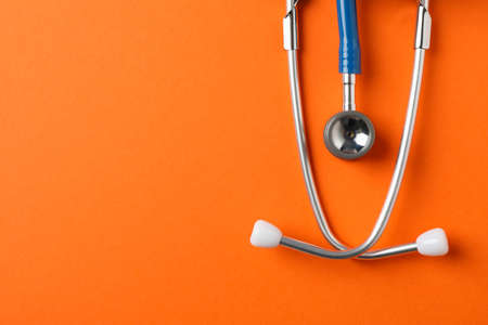 Stethoscope on orange background, space for text. Healthcareの写真素材