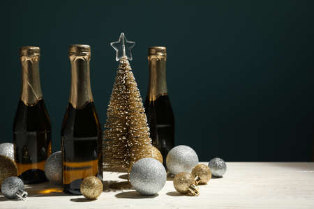 Baubles and champagne mini bottles on white wooden table, space for textの写真素材