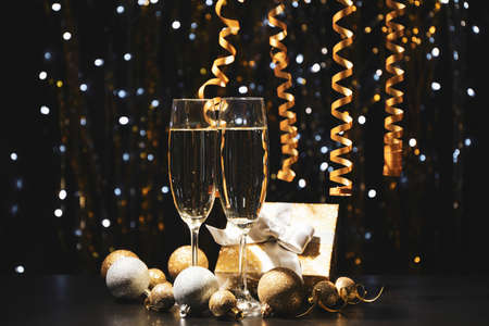 Christmas baubles and champagne glasses on blurred background, copy spaceの写真素材