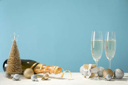 Baubles, champagne glasses and bottle against blue background, space for textの写真素材