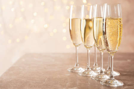 Champagne glasses against blurred lights background, space for textの写真素材