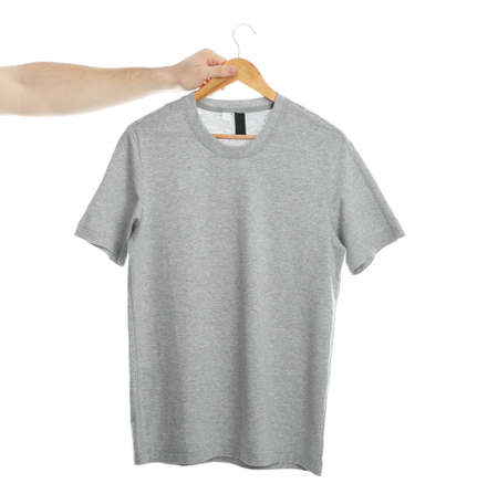 Man holds a hanger with blank t-shirt, isolated on white background