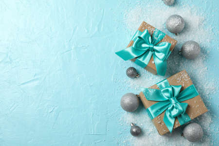 Gift box and glittering Christmas baubles on turquoise background, space for textの写真素材