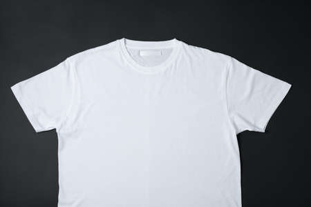 Blank white t-shirt on black background, space for textの写真素材