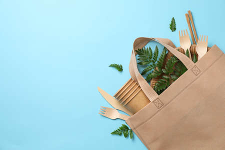 Eco bag with disposable tableware on blue background, space for textの写真素材