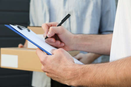 Man with boxes and delivery man outdoor, blank spaceの写真素材