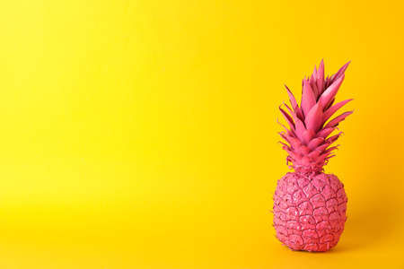 Painted pink pineapple on yellow background, space for textの写真素材