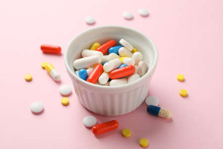 White bowl and different pills on pink background, close upの写真素材