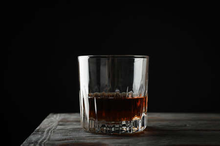 Glass of whiskey on wooden background, space for textの写真素材