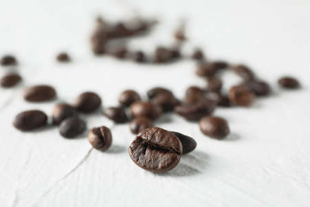 Scattered coffee beans on white background, space for text