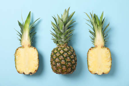 Pineapples on blue background, space for text. Juicy fruit