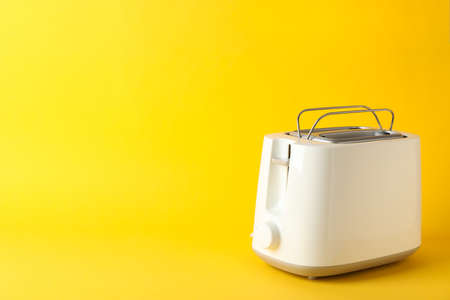 Toaster for bread on yellow background, space for textの写真素材