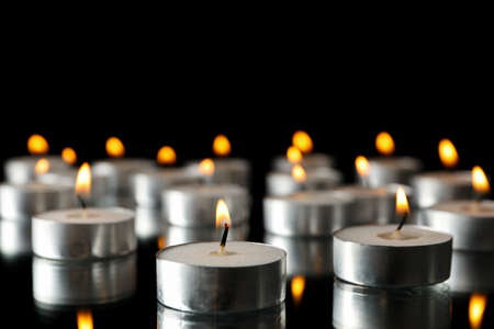 Group of burning candles on black background, space for textの写真素材