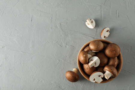 Fresh champignon mushrooms in bowl on grey background, top viewの写真素材