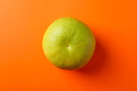 Ripe sweetie fruit on orange background, space for text
