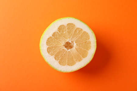 Half of juicy ripe pomelo on orange background, space for textの写真素材