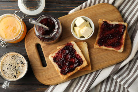 Composition with delicious toasts with jam on wood board, top viewの写真素材