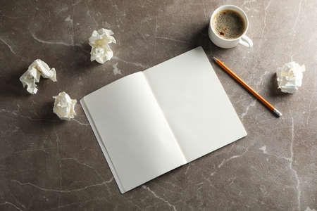 Blank notebook, paper balls, pencil and cup of coffee on grey background, top viewの写真素材